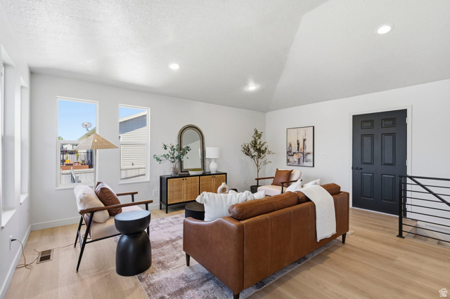 2460 Allison Way Syracuse, UT 84075 - Photo 4 of 24 Spacious living area featuring light wood-finish flooring, recessed lighting, and a vaulted ceiling