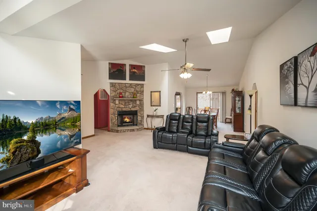 a kitchen with stainless steel appliances granite countertop a stove refrigerator sink dining table and chairs