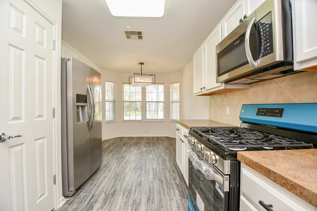 a kitchen with stainless steel appliances granite countertop a stove and a refrigerator