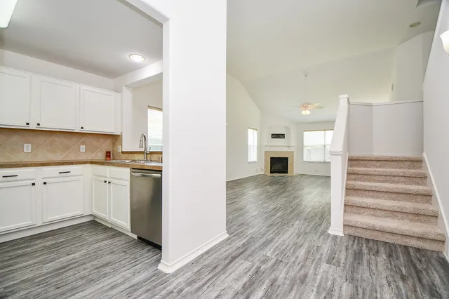 a view of a kitchen with wooden floor and electronic appliances