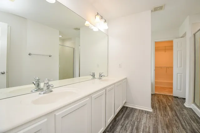 a bathroom with a double vanity sink and mirror