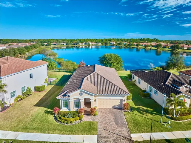an aerial view of a house with a garden and lake view