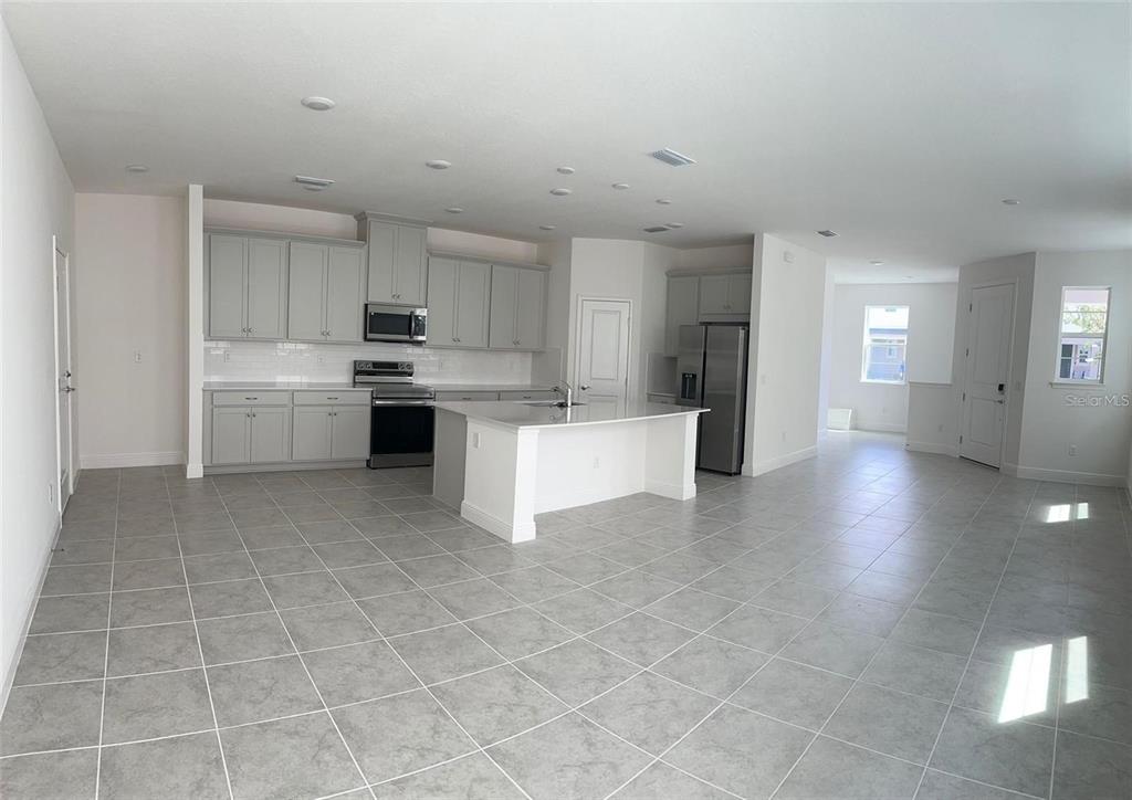 4806 Prairie Preserve Run St. Cloud, FL 34772 - Photo 12 of 21 a large white kitchen with cabinets and wooden floor