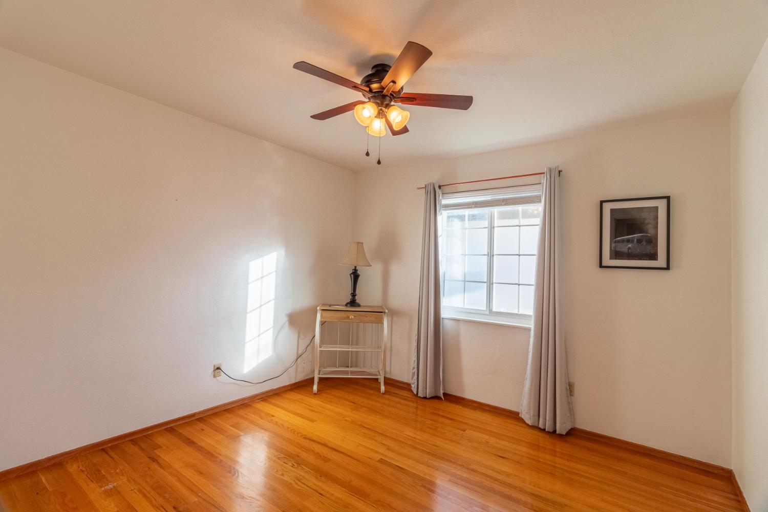 822 South California Street Lodi, CA 95240 - Photo 17 of 34 a view of an empty room with window and wooden floor