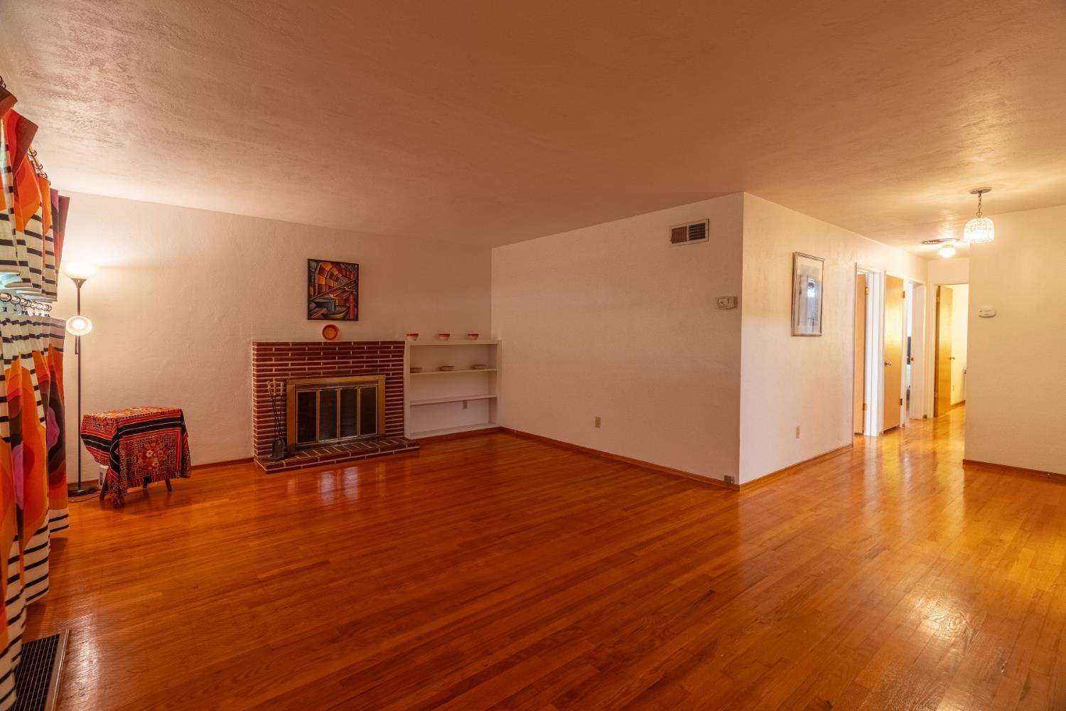 822 South California Street Lodi, CA 95240 - Photo 7 of 34 a view of empty room with wooden floor and fireplace