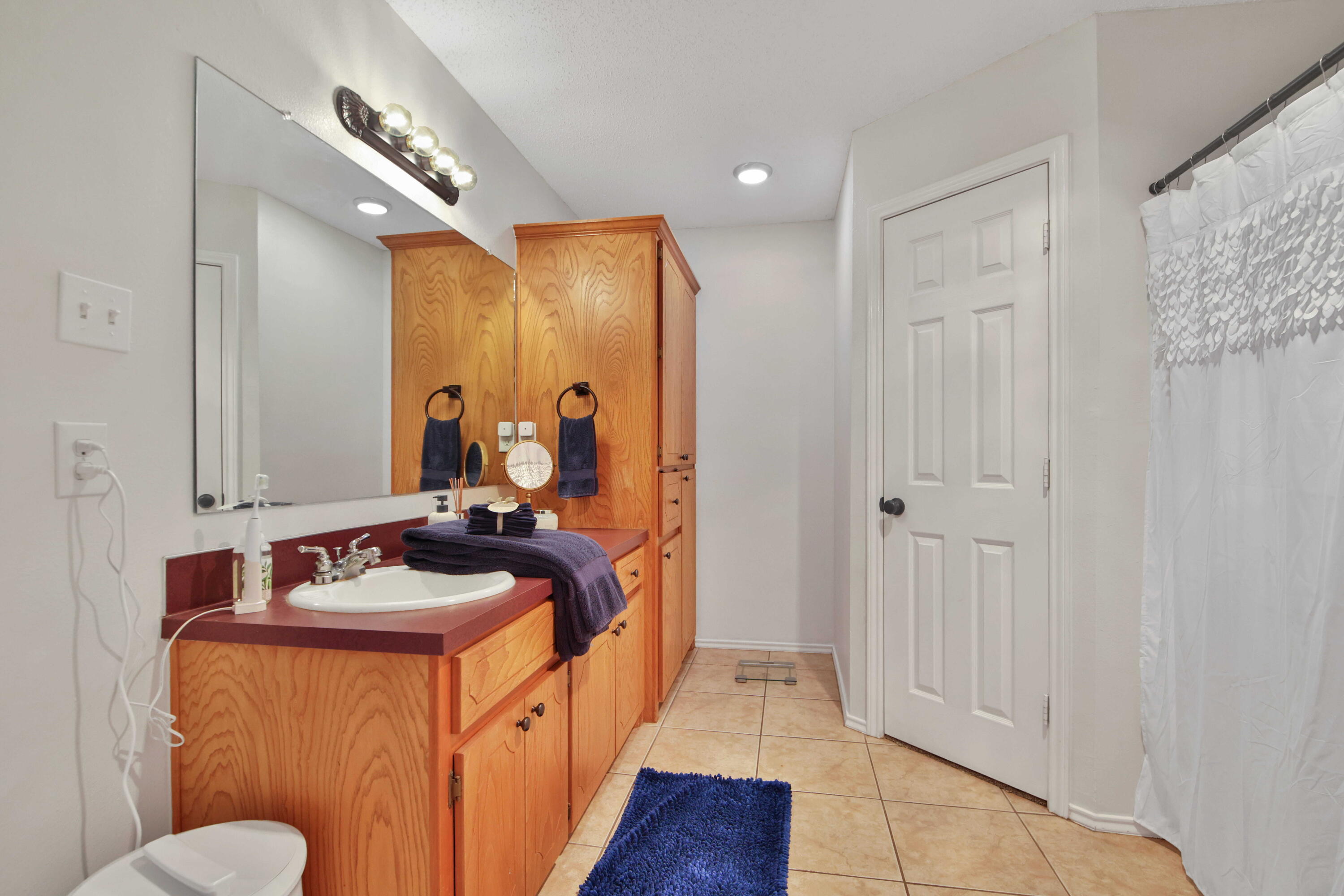 2907 90th Street Lubbock, TX 79423 - Photo 17 of 30 a bathroom with a sink and a mirror