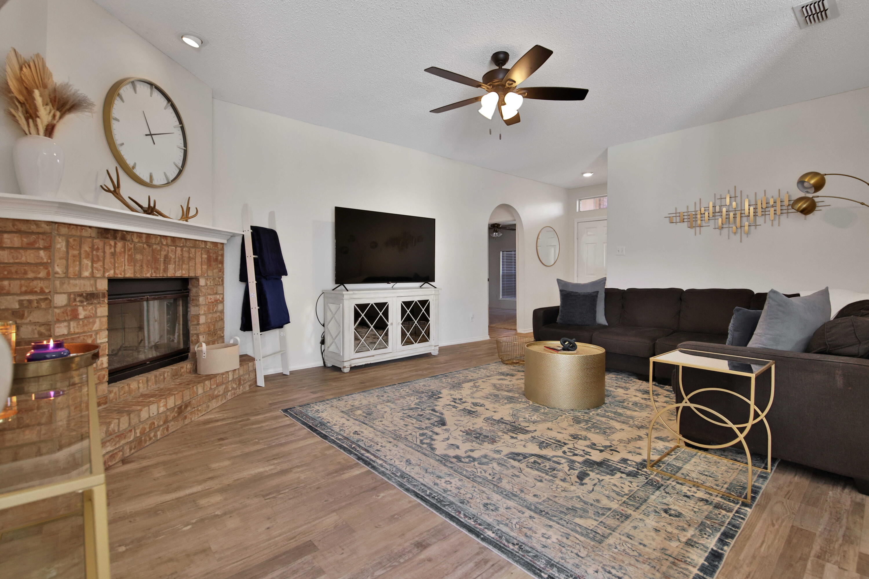2907 90th Street Lubbock, TX 79423 - Photo 19 of 30 a living room with furniture a fireplace and a flat screen tv