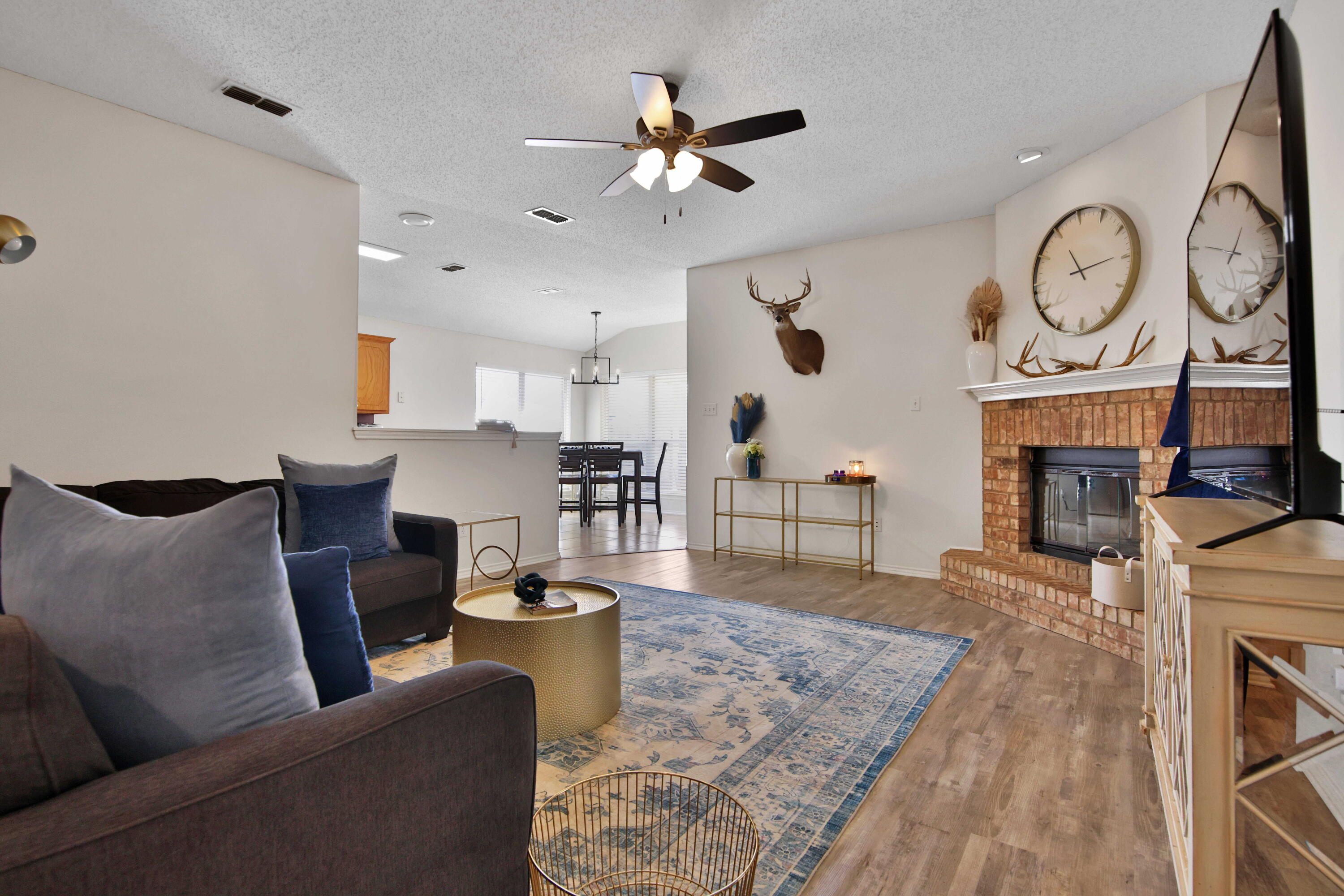 2907 90th Street Lubbock, TX 79423 - Photo 21 of 30 a living room with furniture a fireplace and a ceiling fan