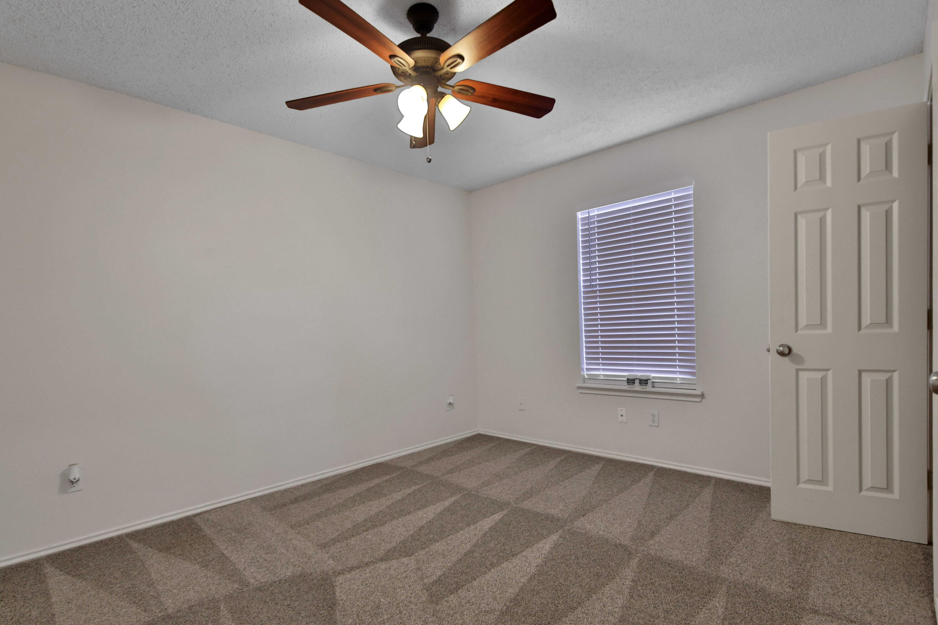 2907 90th Street Lubbock, TX 79423 - Photo 9 of 30 an empty room with windows and fan
