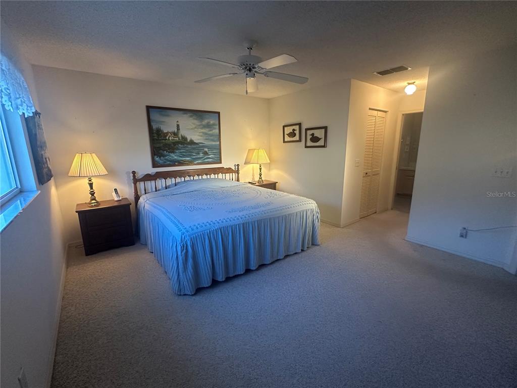 9258 Southwest 91st Circle Ocala, FL 34481 - Photo 16 of 25 a spacious bedroom with a bed and a chandelier