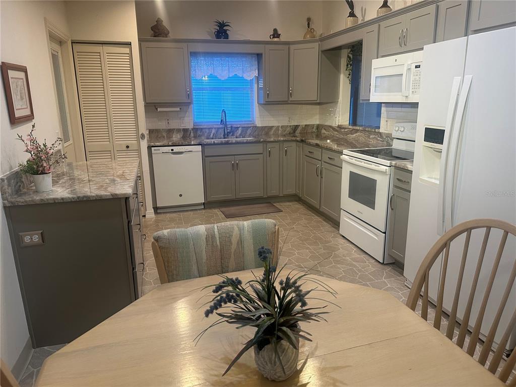 9258 Southwest 91st Circle Ocala, FL 34481 - Photo 3 of 25 a kitchen with stainless steel appliances a sink a stove a refrigerator and cabinets