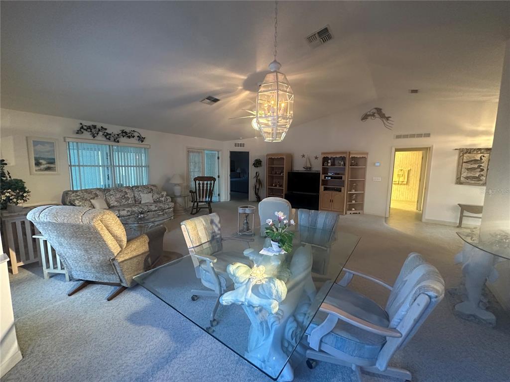 9258 Southwest 91st Circle Ocala, FL 34481 - Photo 5 of 25 a living room with furniture dining area and a chandelier