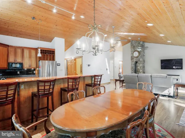 a kitchen with stainless steel appliances granite countertop a refrigerator a stove a sink dishwasher with a dining table and chairs with wooden floor