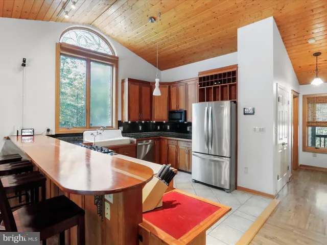 a kitchen with stainless steel appliances granite countertop a refrigerator a sink a stove and island