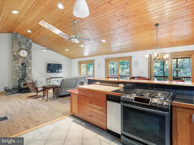 a kitchen with stainless steel appliances granite countertop a refrigerator a stove and a sink with cabinets