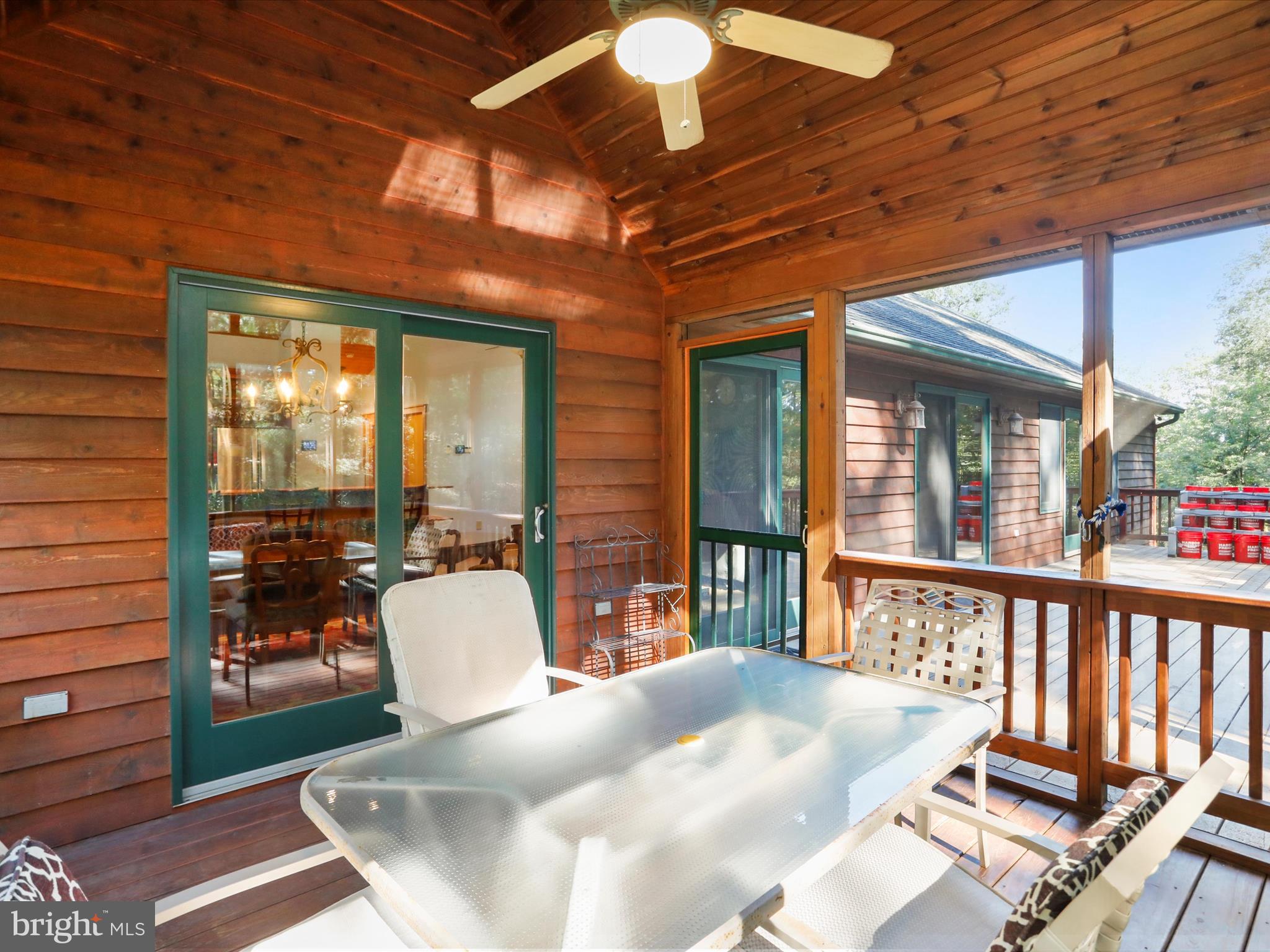 1580 Gaither Road Great Cacapon, WV 25422 - Photo 20 of 65 a view of a patio with a dining table and chairs with wooden floor