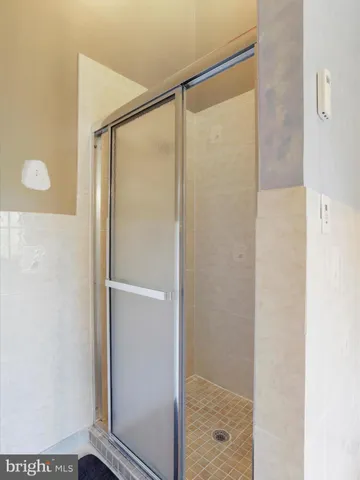 an empty room with wooden floor closet and fan