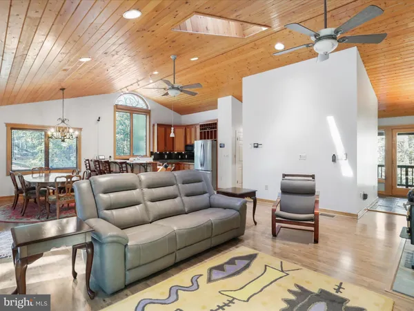 a dining room with furniture a chandelier and wooden floor