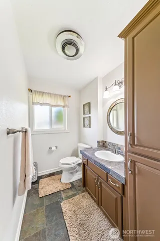 a bathroom with a sink a toilet and a mirror
