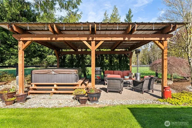 a view of backyard with seating space and trees in the background