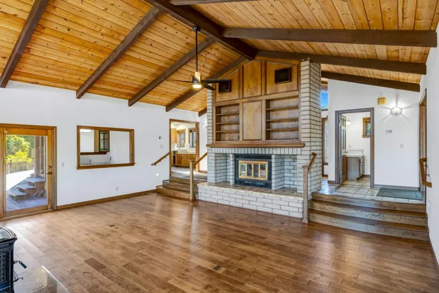 a view of a livingroom with wooden floor and a fireplace