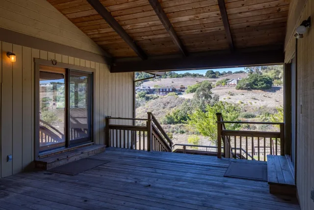 a view of a porch with wooden floor in front of a house