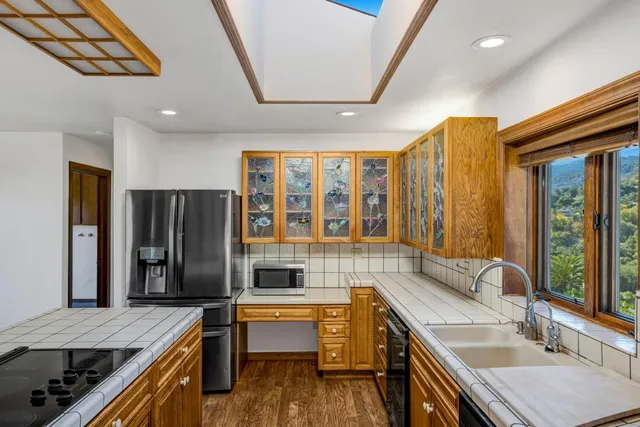 a kitchen with stainless steel appliances granite countertop a sink and wooden cabinets