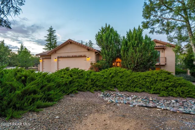 a front view of a house with a yard and trees