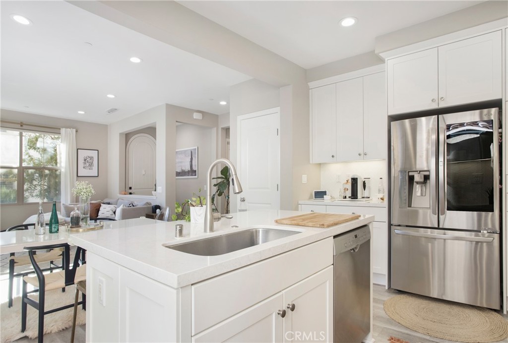 128 Nature Walk Irvine, CA 92618 - Photo 15 of 24 a kitchen with white cabinets and stainless steel appliances