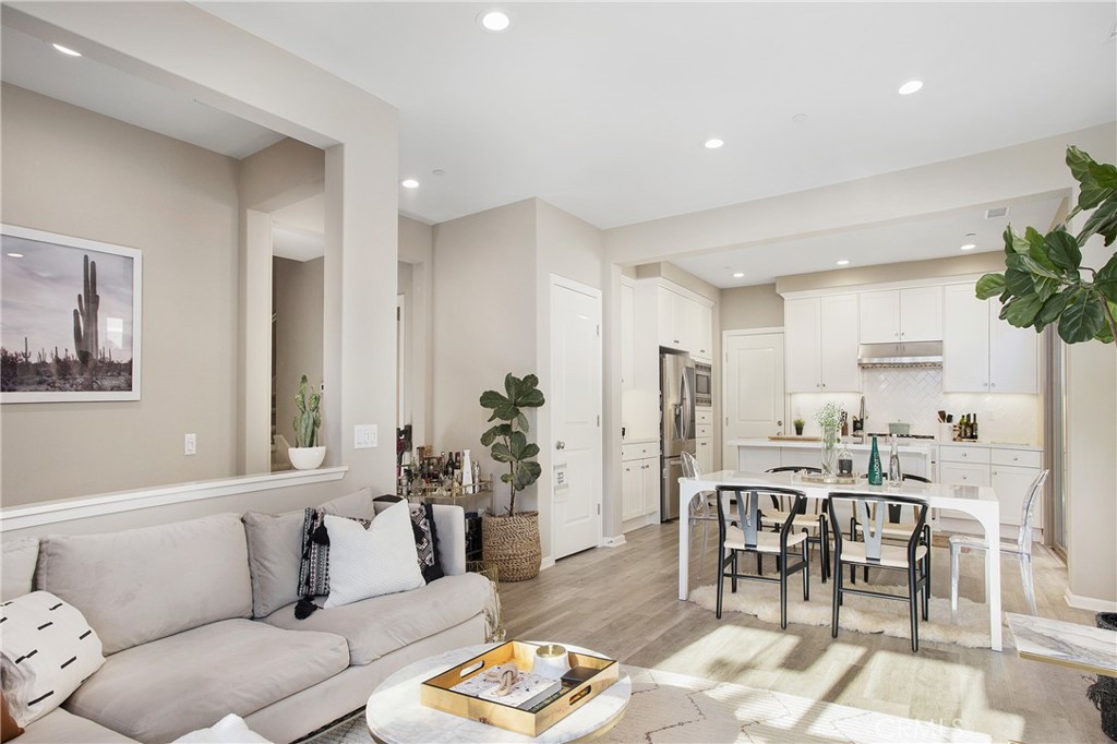 128 Nature Walk Irvine, CA 92618 - Photo 4 of 24 a living room with furniture and a dining table with kitchen view