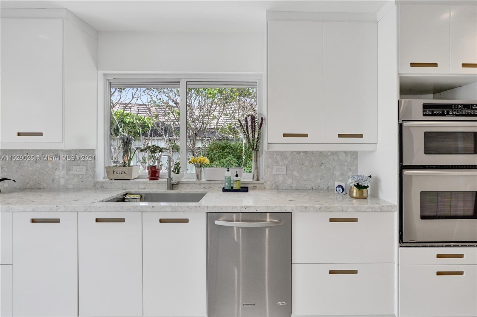 4425 Island Road Miami, FL 33137 - Photo 13 of 30 a kitchen with stainless steel appliances granite countertop white cabinets and a window