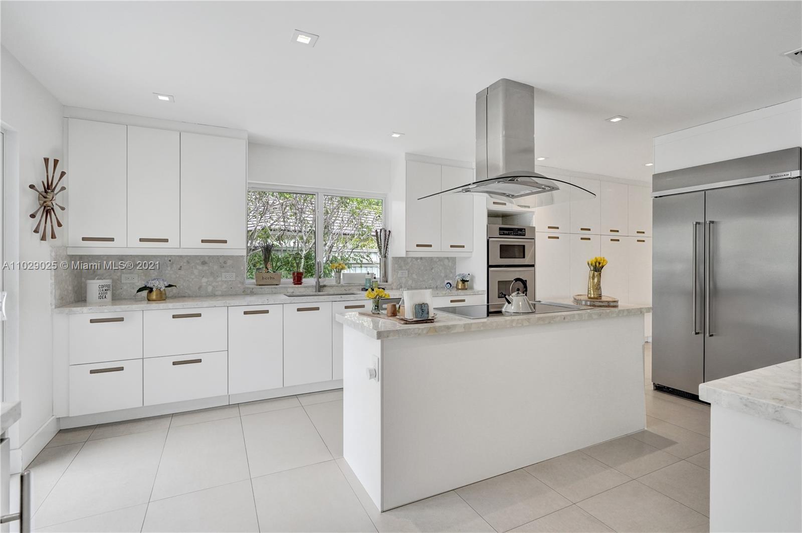 4425 Island Road Miami, FL 33137 - Photo 15 of 30 a kitchen with kitchen island granite countertop a sink cabinets and stainless steel appliances