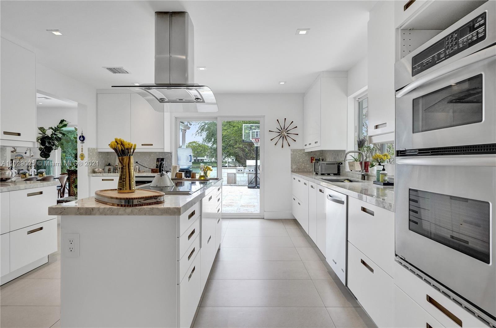 4425 Island Road Miami, FL 33137 - Photo 16 of 30 a kitchen with stainless steel appliances a white cabinets stove and sink