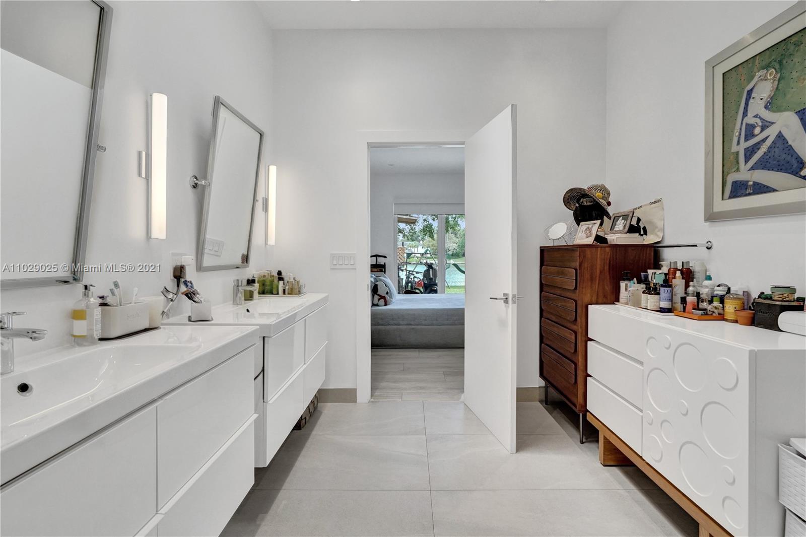 4425 Island Road Miami, FL 33137 - Photo 21 of 30 a en suite bathroom with a double vanity sink and a mirror