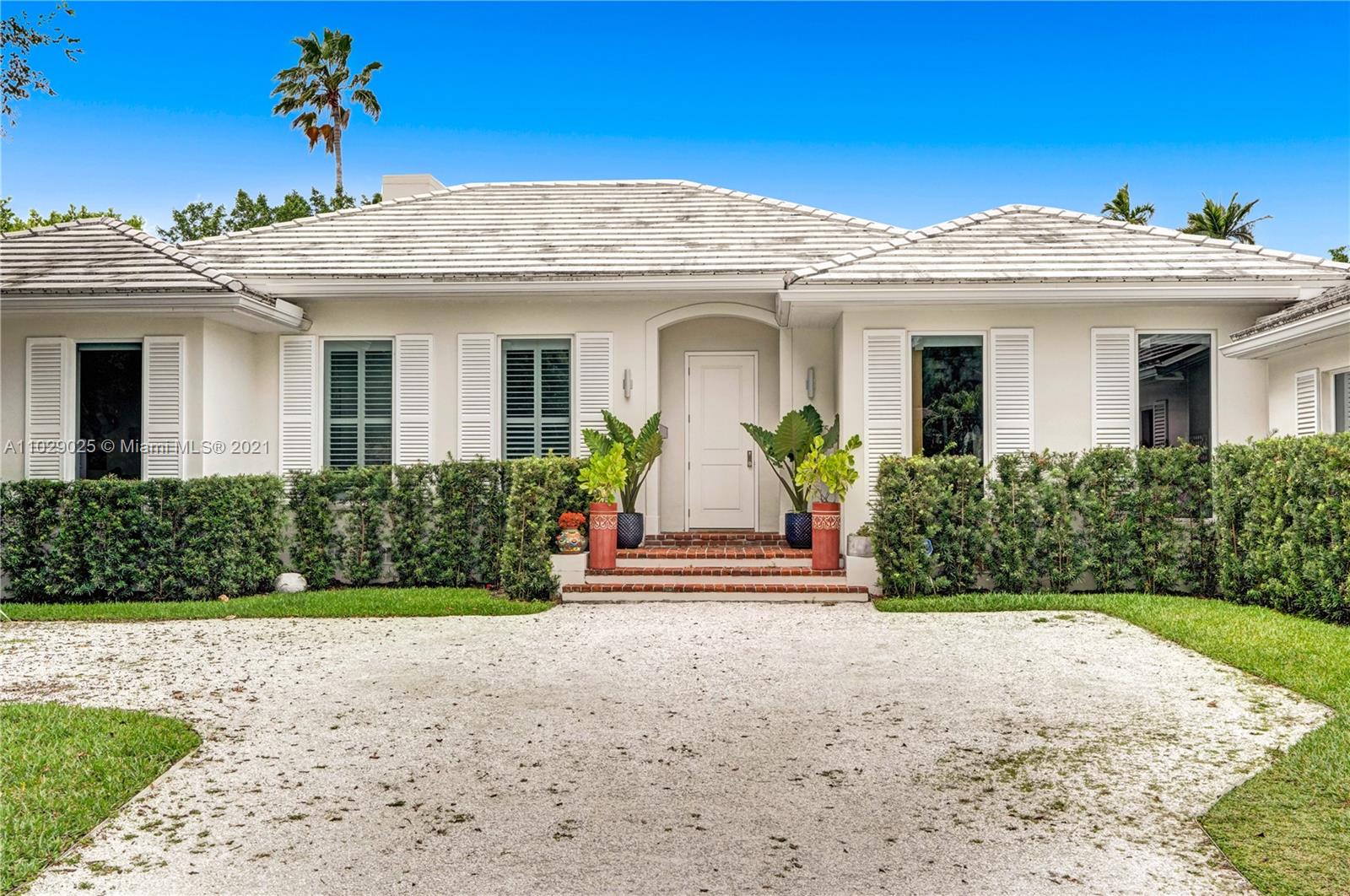 4425 Island Road Miami, FL 33137 - Photo 25 of 30 a view of a white house with a yard and potted plants