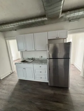 a kitchen with cabinets stainless steel appliances and wooden floor