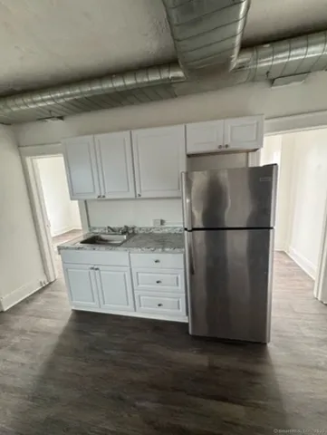a kitchen with cabinets stainless steel appliances and wooden floor
