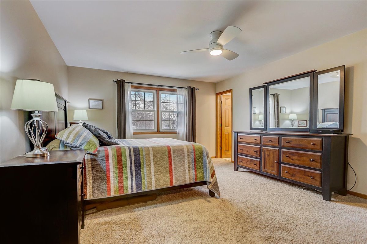 827 Manchester Street Naperville, IL 60563 - Photo 22 of 48 a spacious bedroom with a bed and dresser with mirror