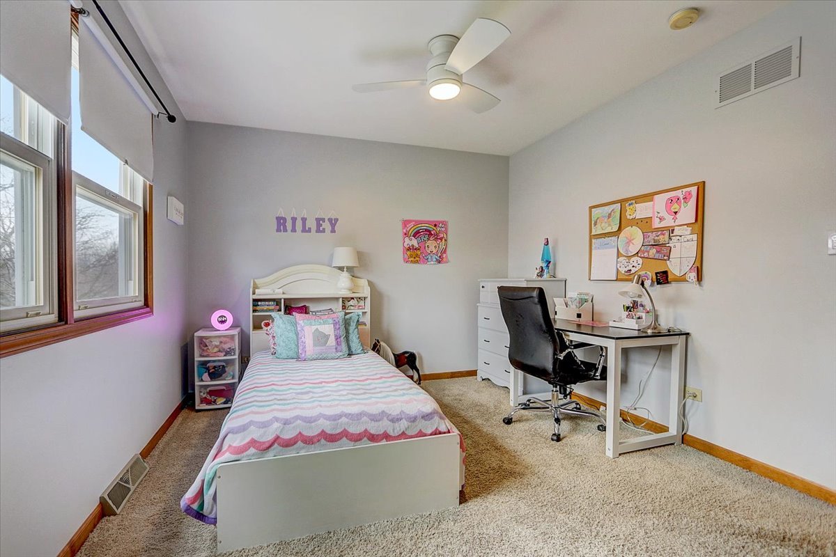 827 Manchester Street Naperville, IL 60563 - Photo 27 of 48 a bedroom with a bed and a chandelier