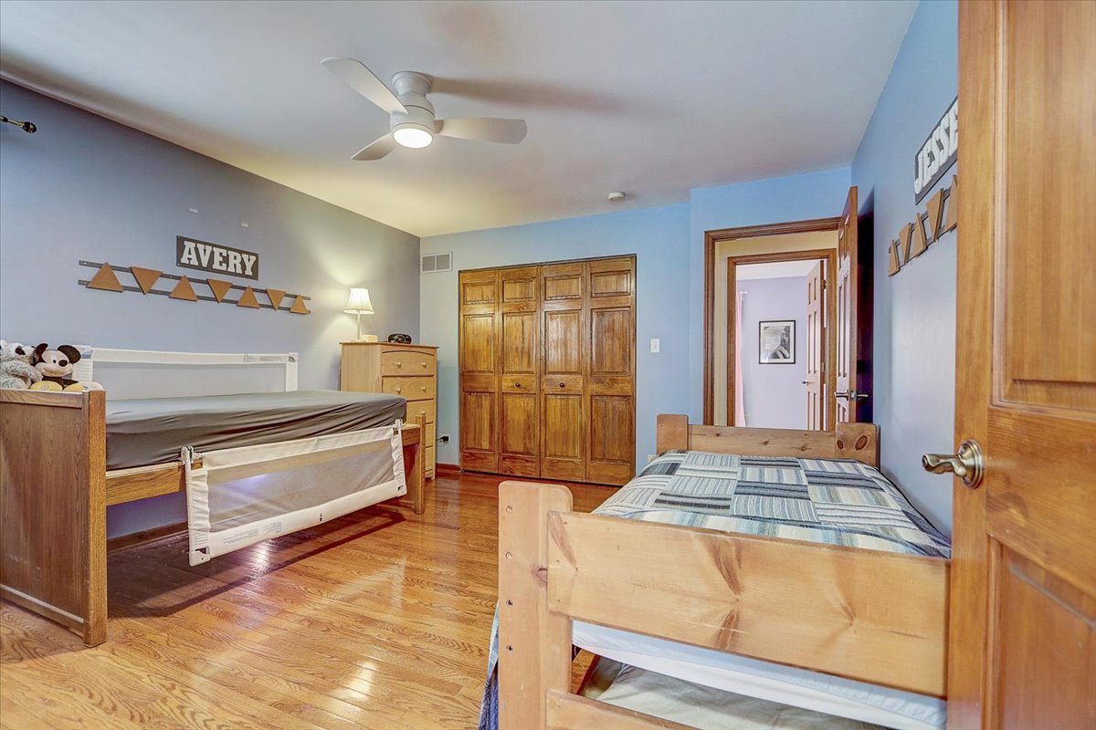 827 Manchester Street Naperville, IL 60563 - Photo 32 of 48 a spacious bedroom with a bed and a dresser