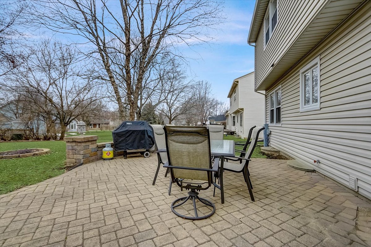 827 Manchester Street Naperville, IL 60563 - Photo 42 of 48 a view of a backyard with table and chairs and a barbeque