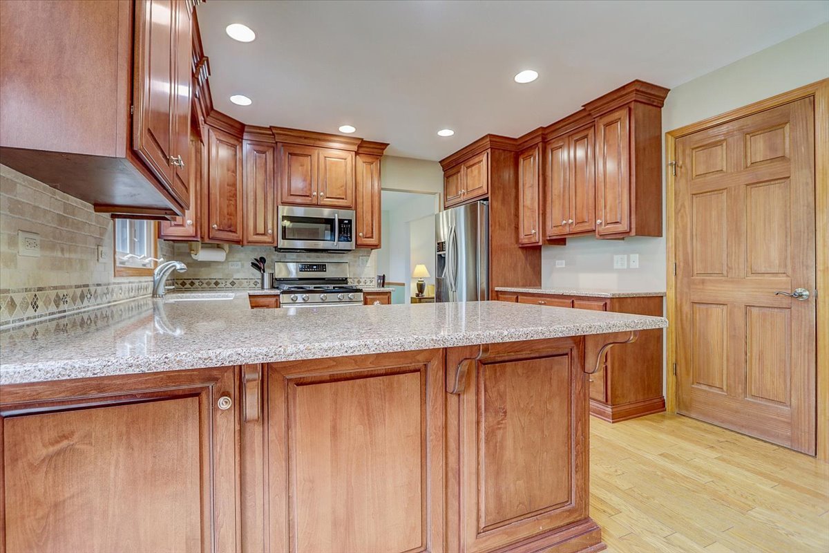827 Manchester Street Naperville, IL 60563 - Photo 7 of 48 a kitchen with stainless steel appliances granite countertop a sink a stove and a refrigerator