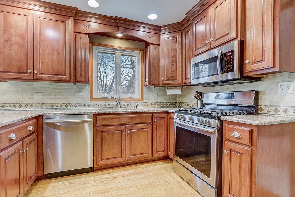 827 Manchester Street Naperville, IL 60563 - Photo 8 of 48 a kitchen with stainless steel appliances granite countertop a stove and a microwave