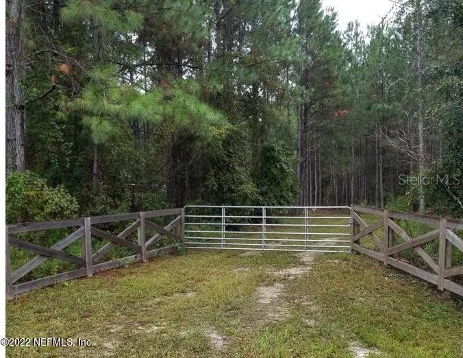 a view of a yard with wooden fence