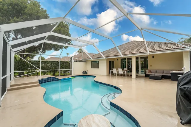 a view of a swimming pool with a patio and a yard