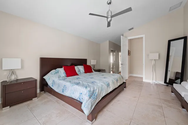 a bedroom with a bed and a flat tv screen on a dresser