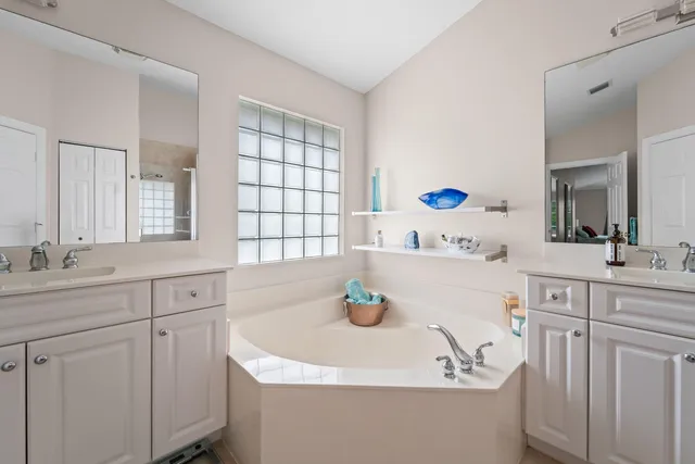 a bathroom with a tub sink and mirror
