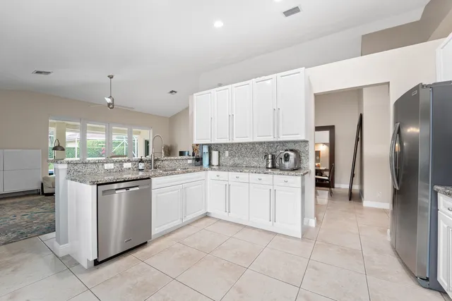 a kitchen with stainless steel appliances granite countertop a refrigerator and a stove top oven