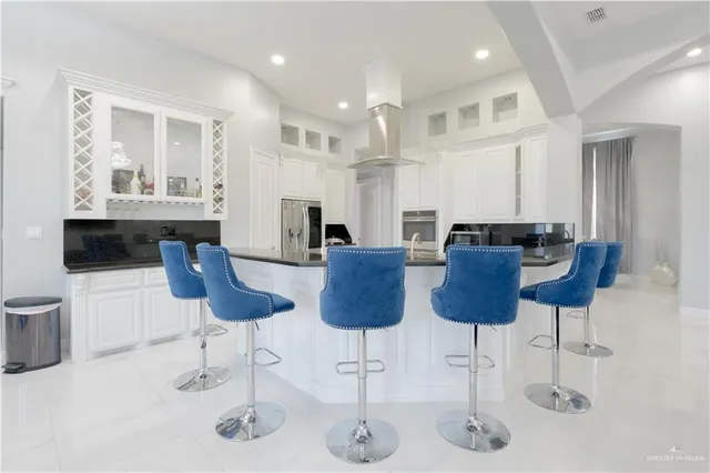 a kitchen with stainless steel appliances kitchen island granite countertop a table and chairs