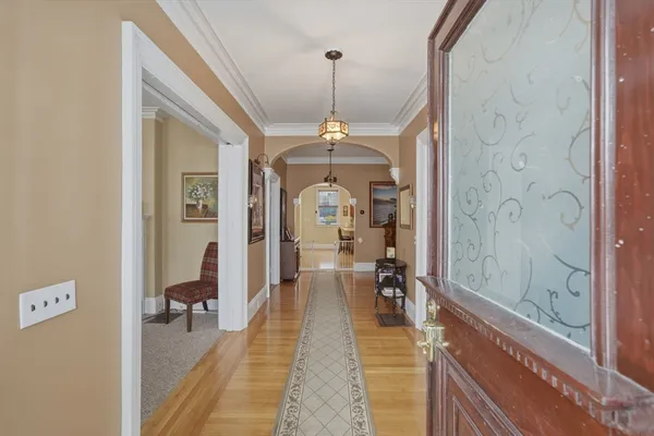 a hallway with a dining table and a chandelier